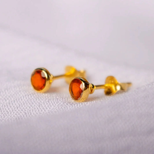 Carnelian mini stud earrings in gold on white cloth