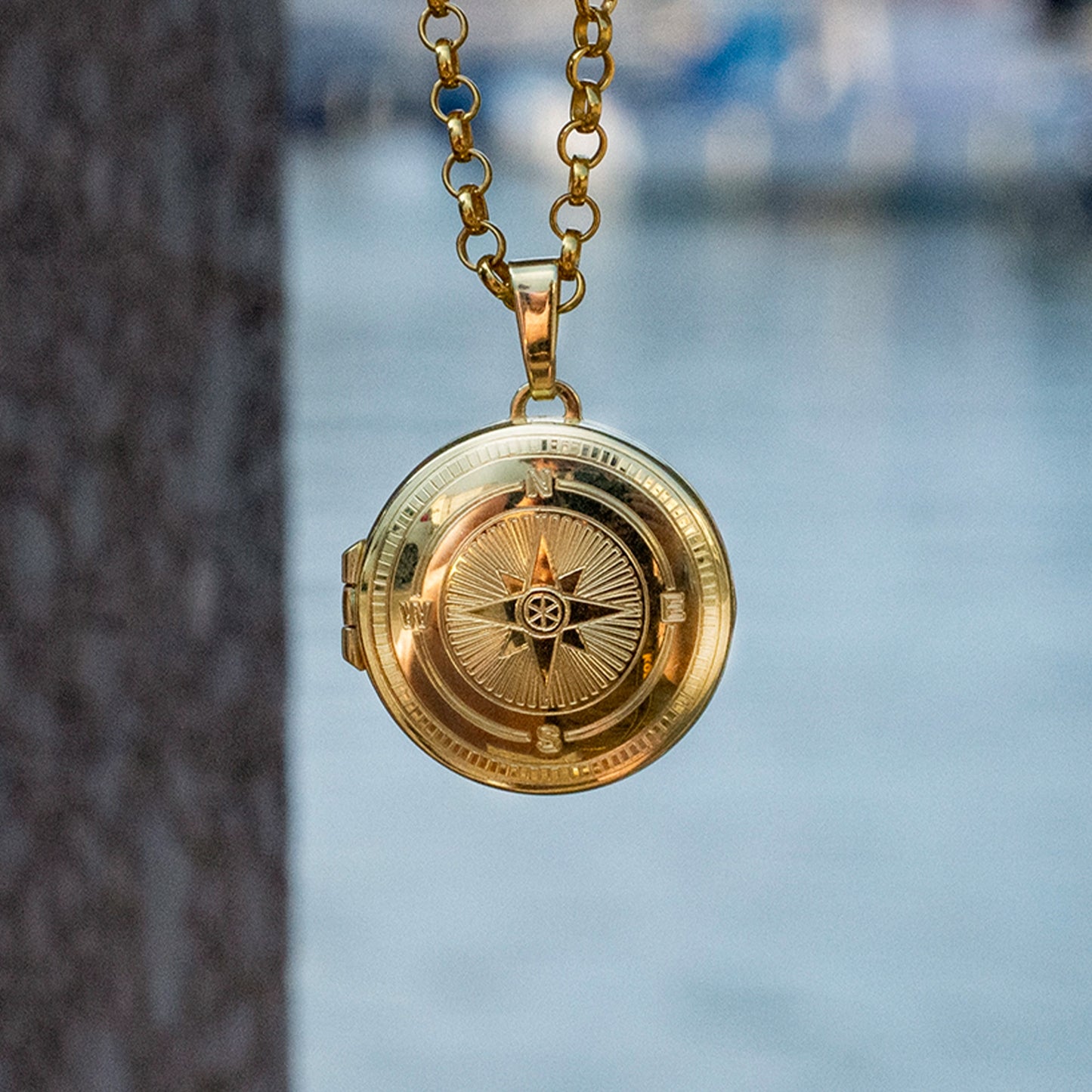 Close-up of the compass locket open showing two round photo panels inside on a white background – highlights personalised photo feature
