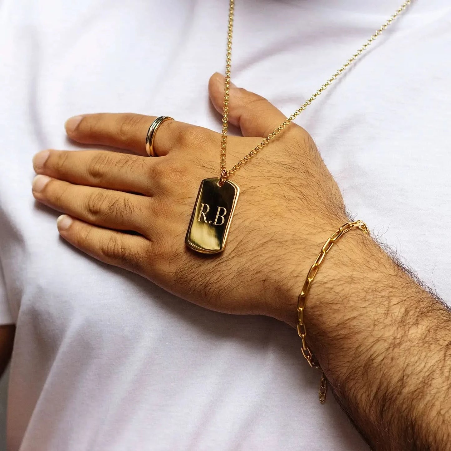 model wearing gold dogtag with chain and front engraving