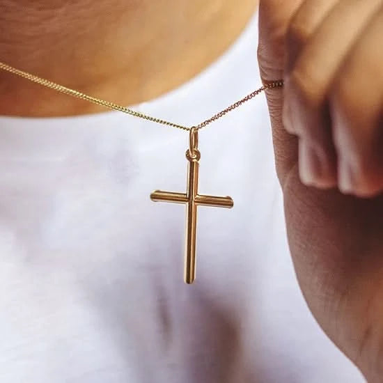 man wearing gold cross necklace, sturdy gold curb chain, high polish finish, rounded edges, solid gold pendant for men and women