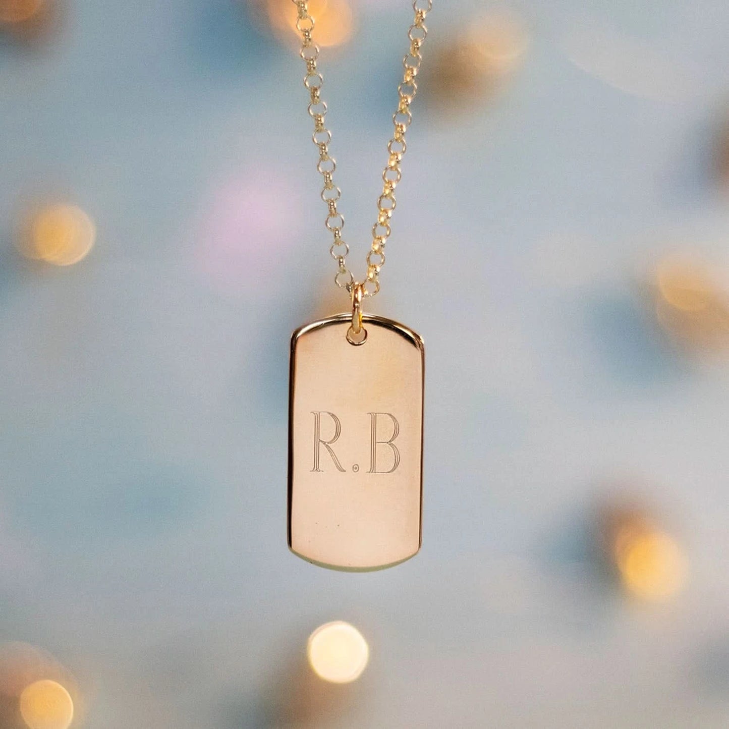 Personalized gold dog tag necklace with engraved initials R.B.