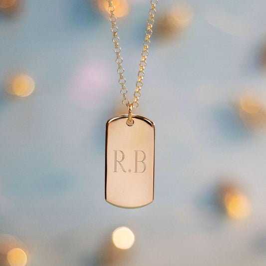 Personalized gold dog tag necklace with engraved initials R.B.