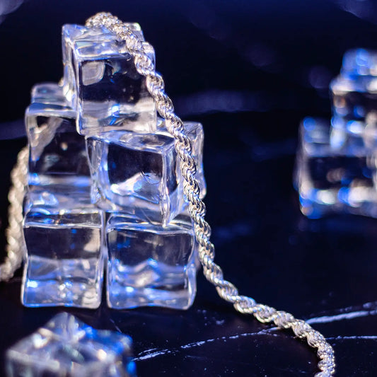 Men's sterling Silver Rope Chain necklace 5.5mm wide, draped on a pile of five ice cubes on a blue background