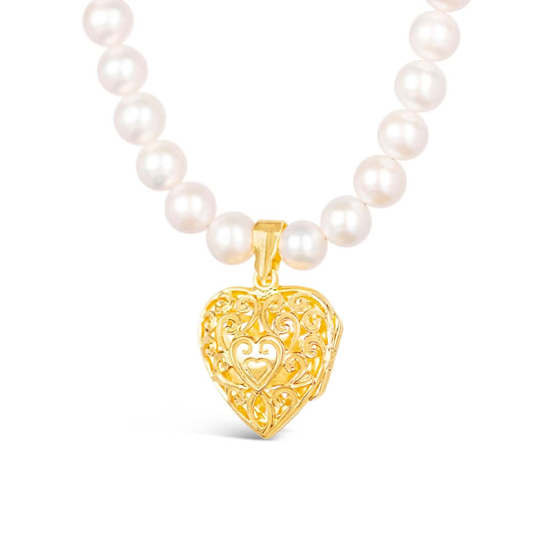 detail of white pearl necklace with gold filigree heart locket