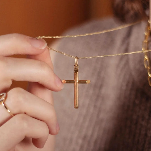Gold Cross Necklace Styled with Layered Chains on Woman in Cozy Sweate