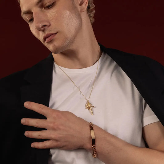 Male model wearing a solid 9ct gold ID bracelet with layered gold cross and St Christopher necklaces