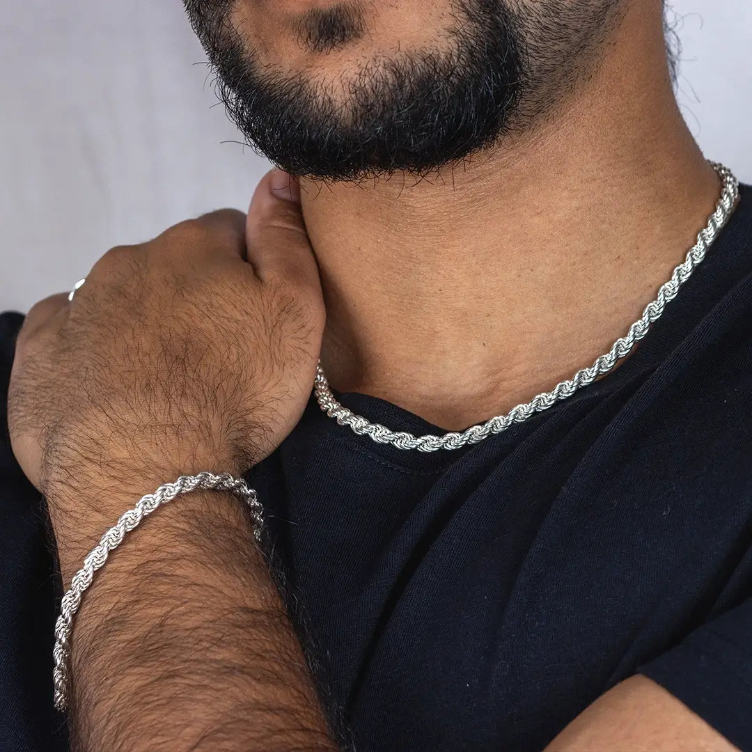 Man wearing matching sterling silver rope chain necklace and bracelet, styled with a black t-shirt