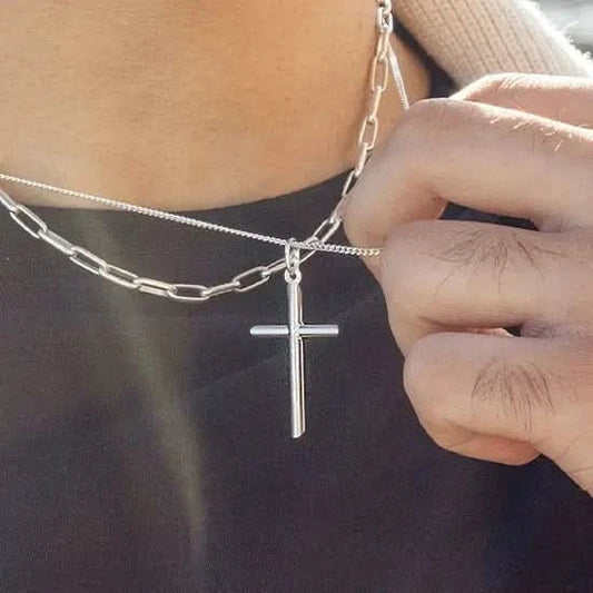 man wearing silver cross necklace, sturdy silver curb chain, high polish finish, rounded edges, religious Christian pendant for men and women, paperclip chain, holding chain