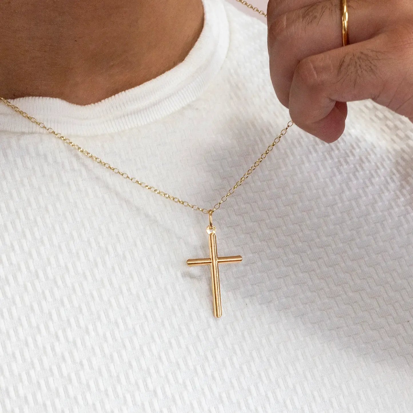 solid Gold cross necklace on a white shirt