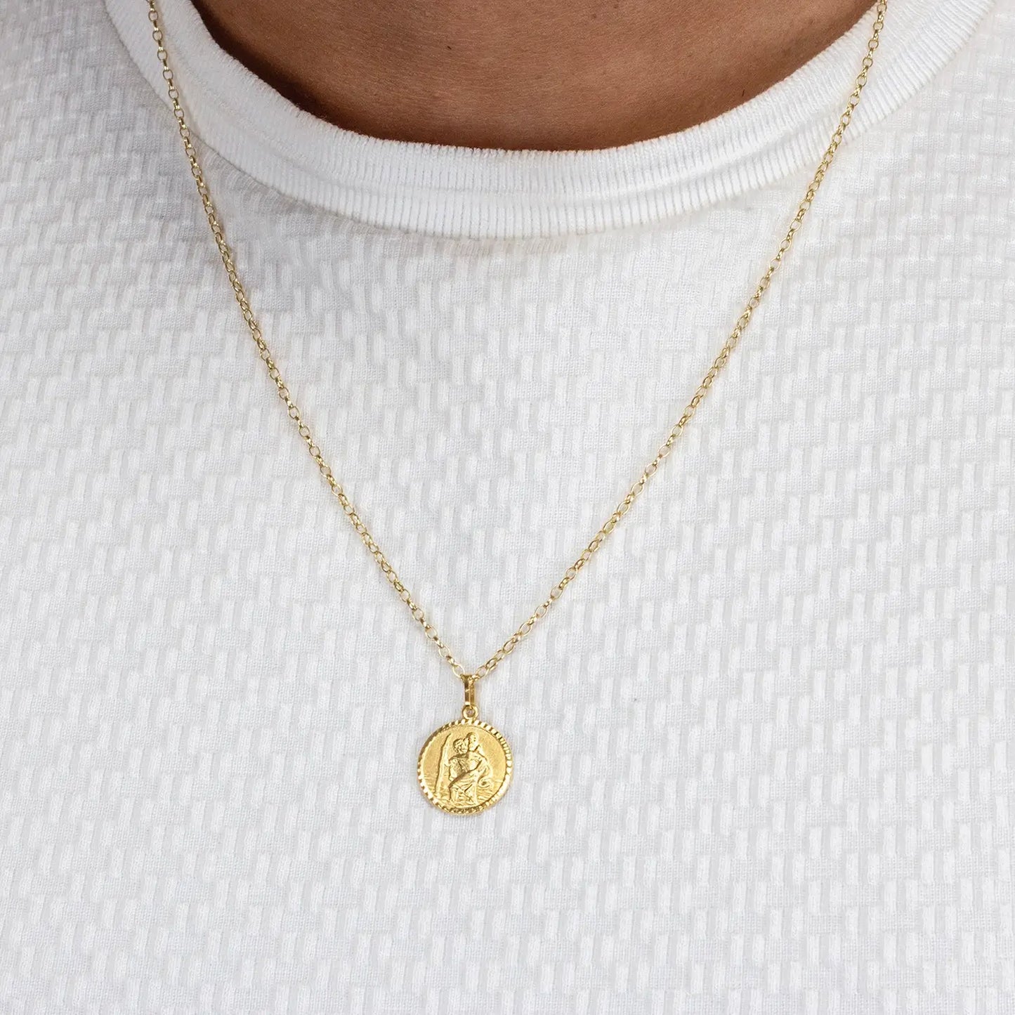 Gold st Christopher necklace with a round pendant on a white background