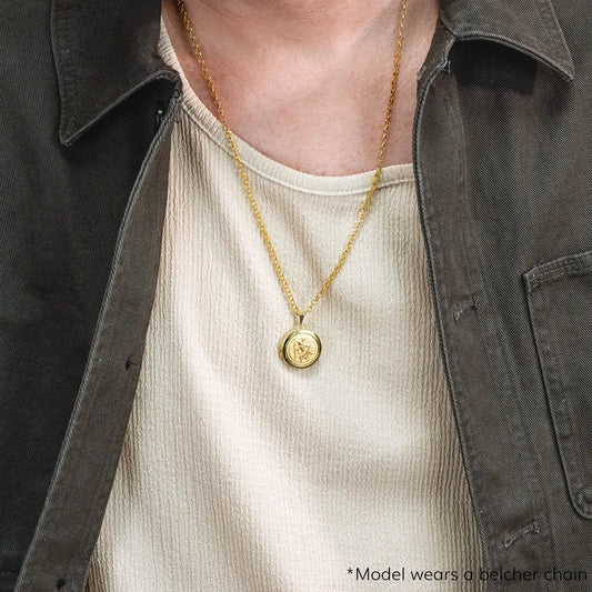 photograph of st christopher locket in gold showing the front of the locket and worn on a male model
