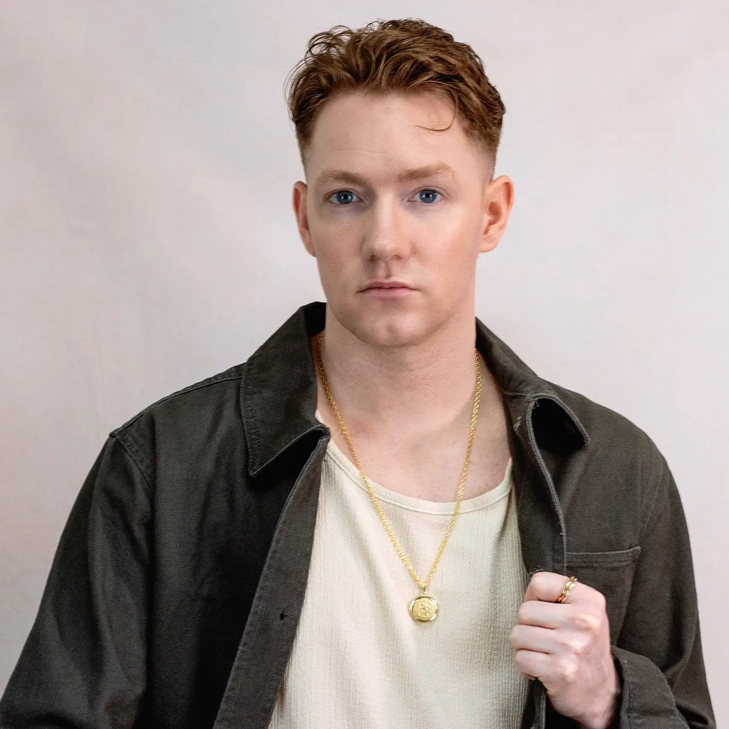 wide photograph of st christopher locket in gold showing the front of the locket on a male model