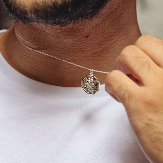 Man wearing white gold St. Christopher pendant necklace with octagonal medal on fine chain
