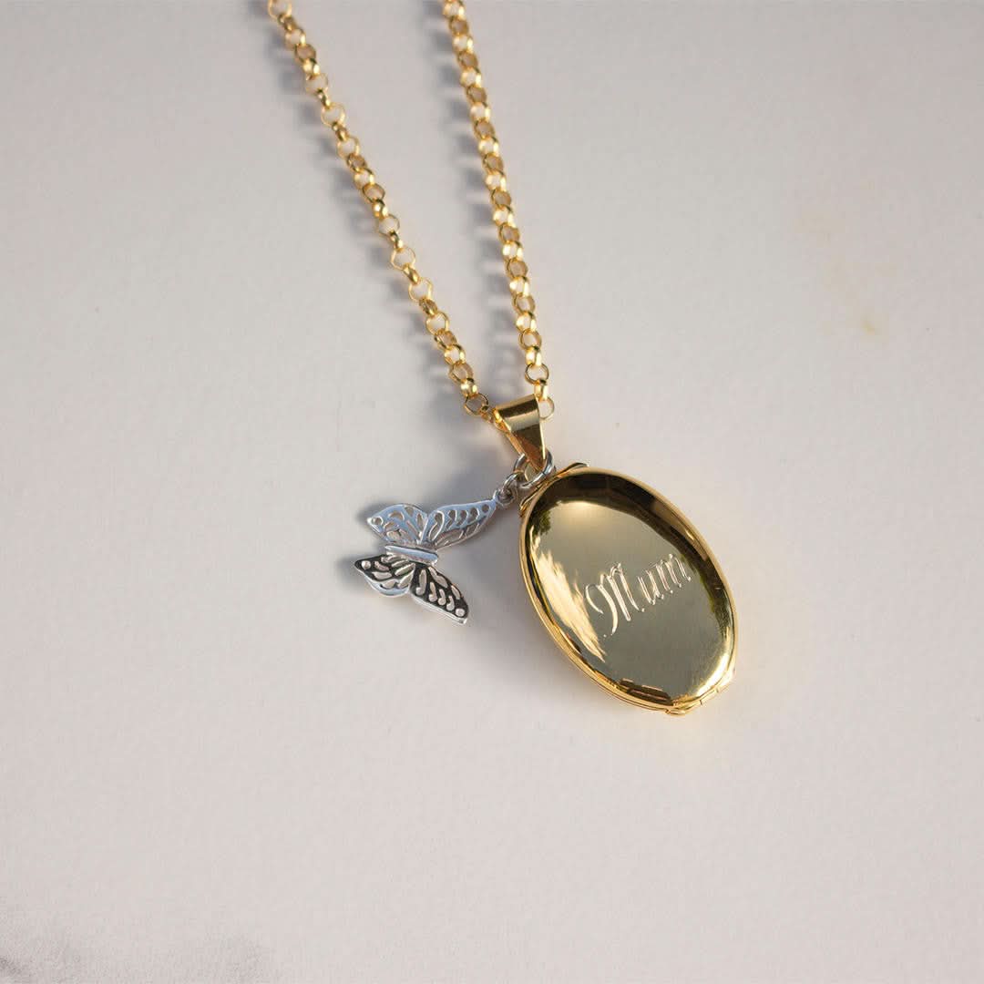 Gold oval engraved locket necklace with silver butterfly charm on belcher chain, engraved with ‘Mum’