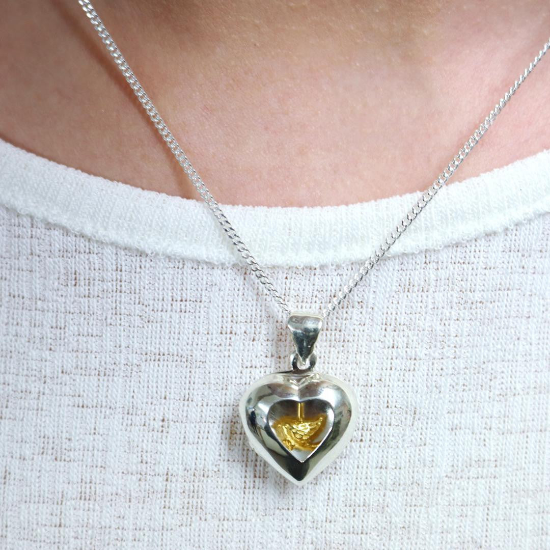 Lily Blanche sterling silver heart locket with gold bird inside modelled