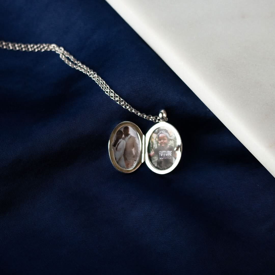 opened small oval diamond locket in silver on a piece of blue fabric