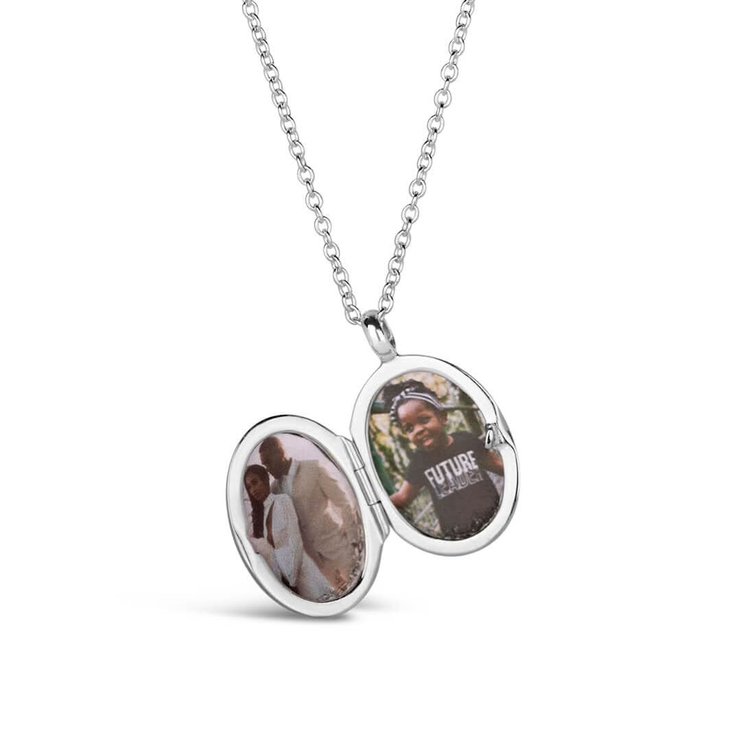 opened small oval diamond locket in silver on a white background