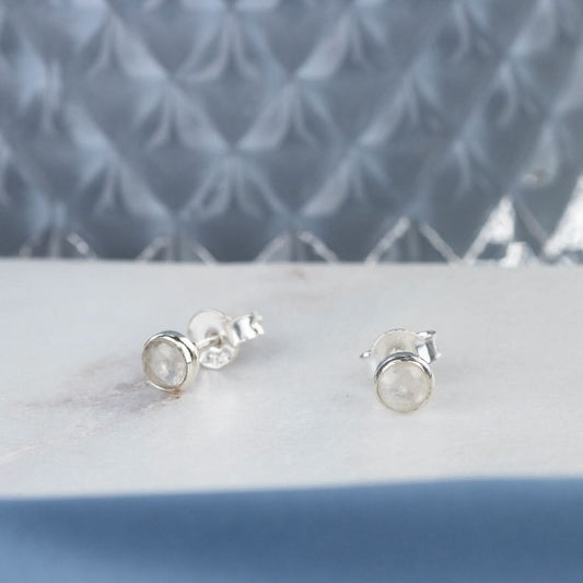 Silver moonstone stud earrings on a white platter