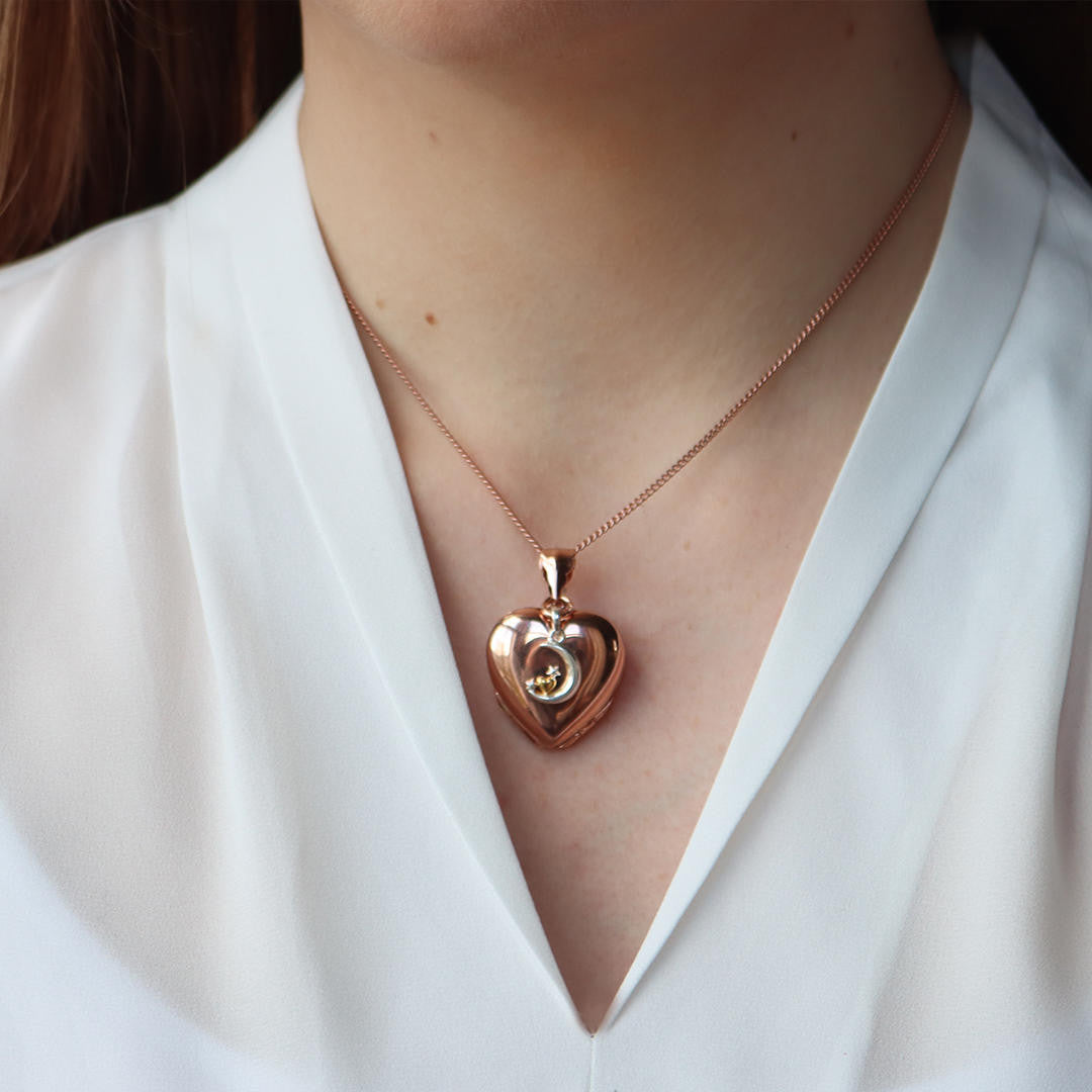 model wearing rose gold curb chain with rose gold heart locket and moon and stars charm
