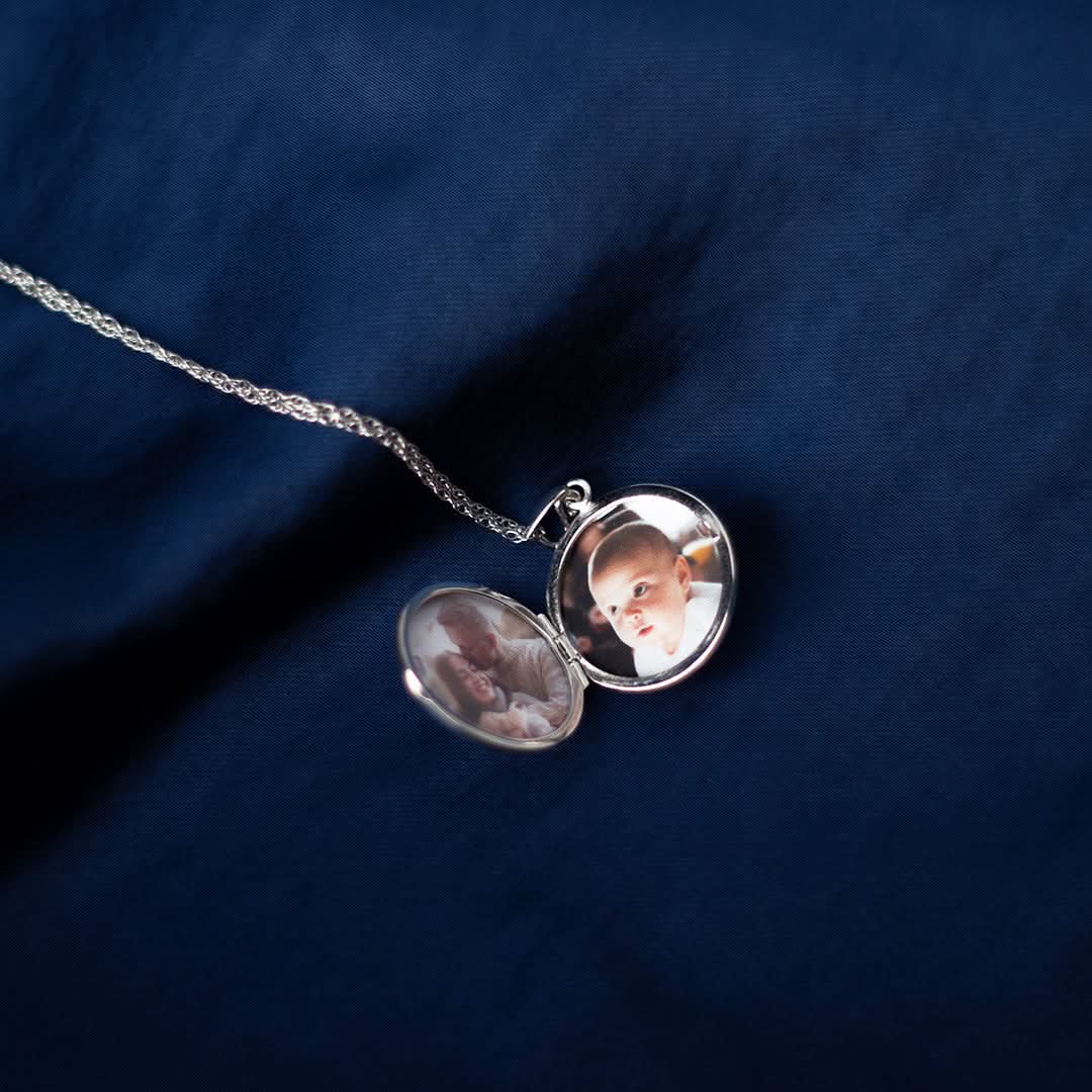 opened white gold round diamond locket on a piece of blue fabric