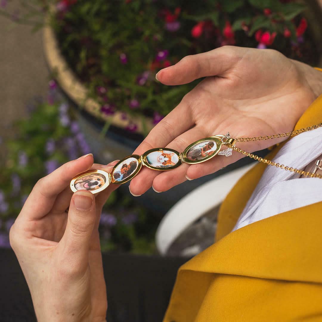 model holding gold oval shaped locket with four photos