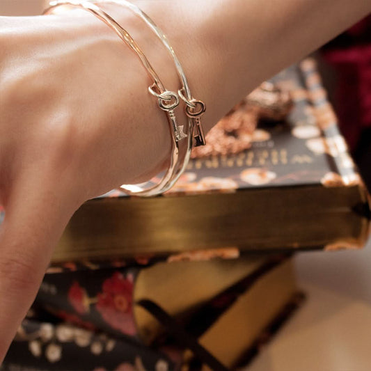 close up of model wearing two key bangles