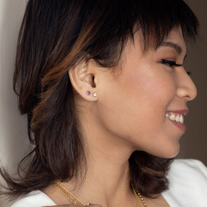Close up model image wearing white quartz mini stud earrings in gold