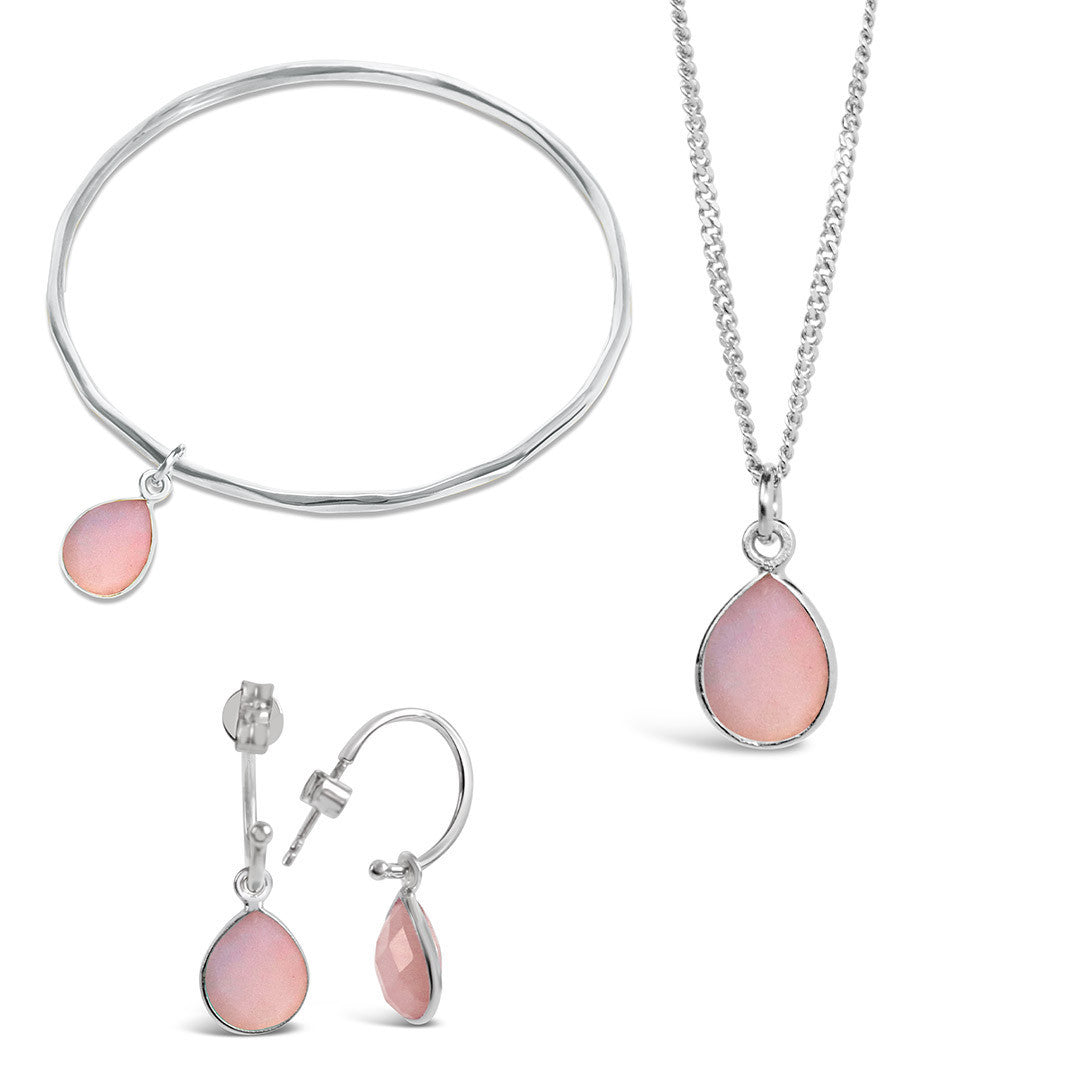 pink opal silver charm bangle, necklace and drop hoop earrings on a white background