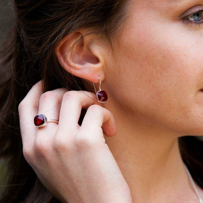 model wearing garnet cocktail ring in silver with matching earrings