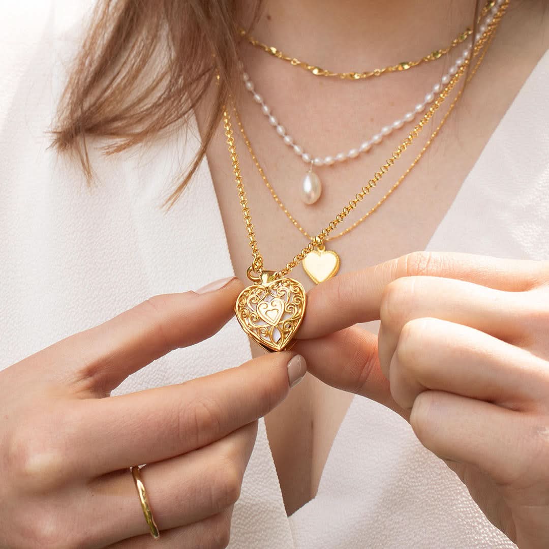 close up of model wearing key locket in gold