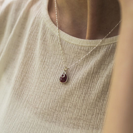 model wearing white gold beaded chain with silver birthstone and initial