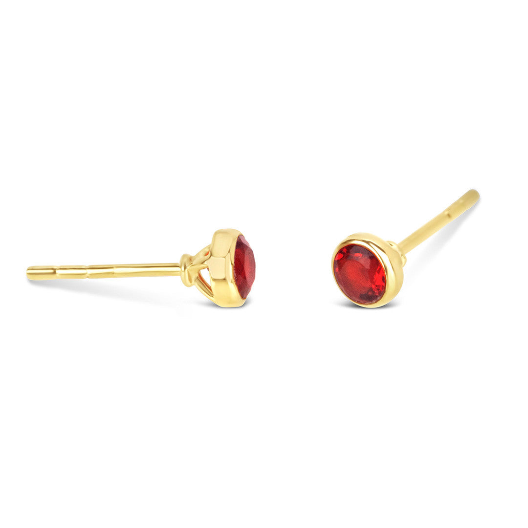 Garnet mini stud earrings in gold facing the side on a white background