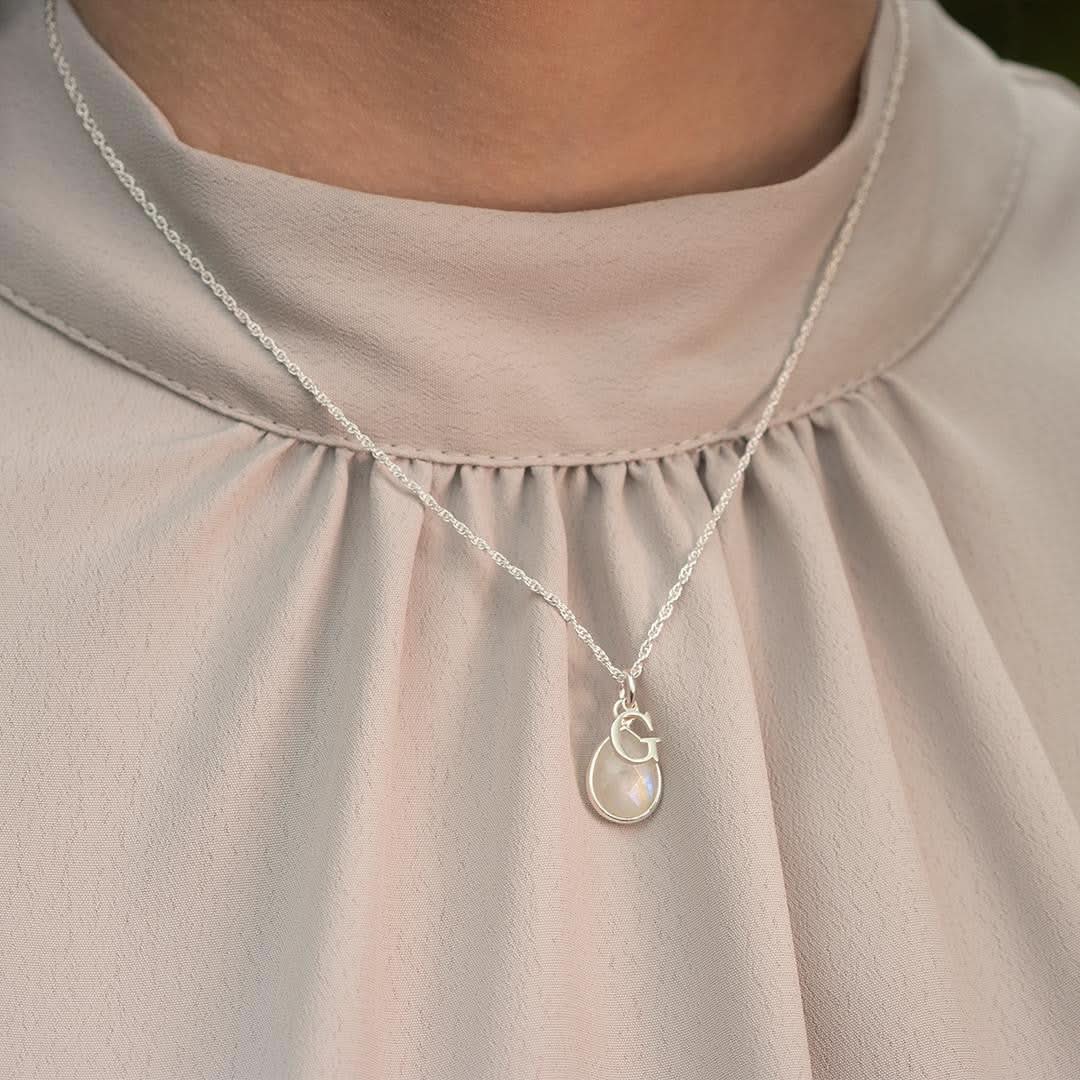close up of model wearing silver moonstone charm necklace