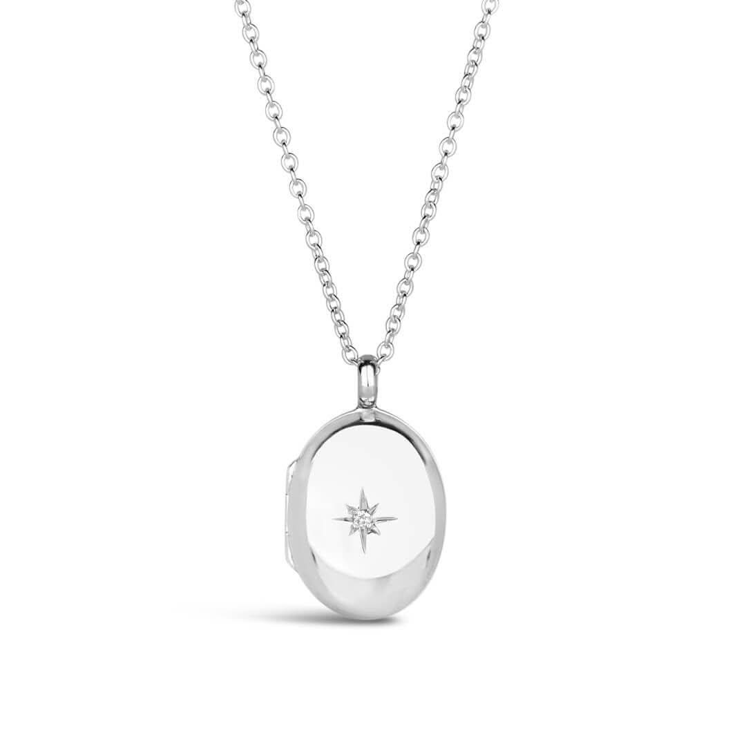 small oval diamond locket in silver on a white background