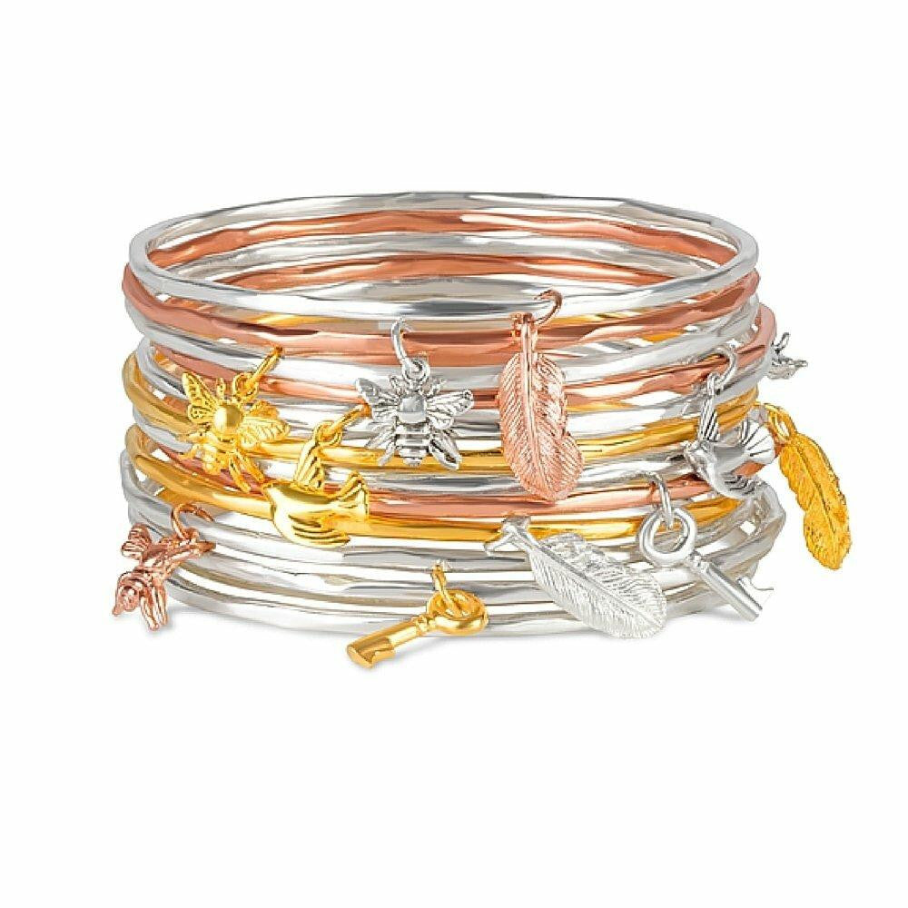 stack of bangles with different charms attached on a white background