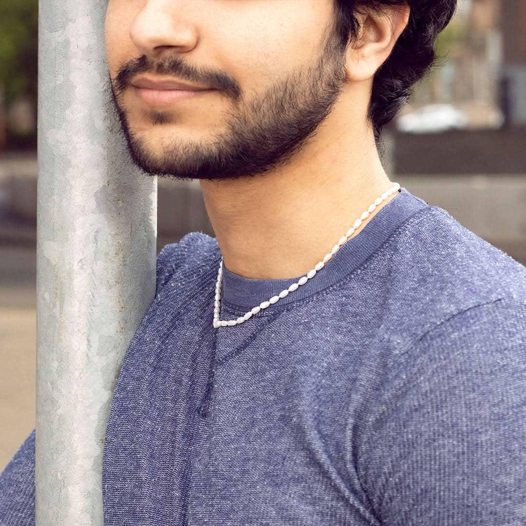 closeup of model wearing men's seed pearl necklace