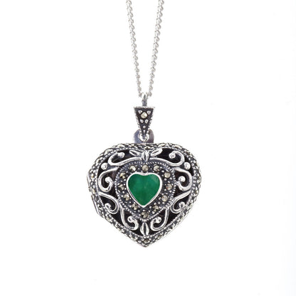 emerald vintage heart locket in silver on a white background