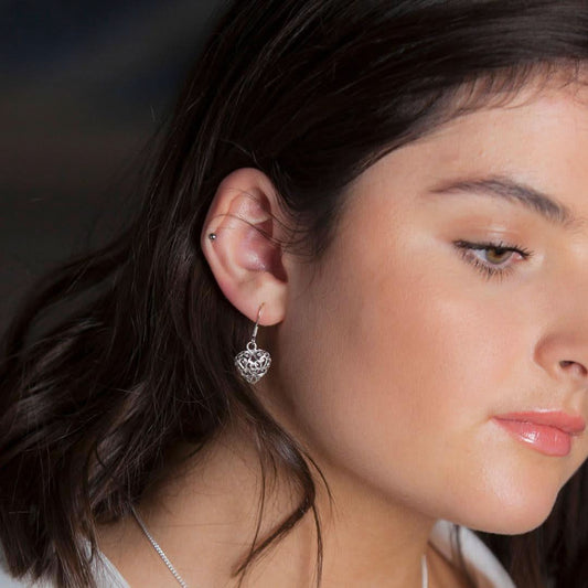 model wearing silver heart earrings