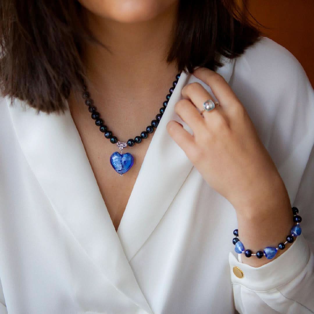 model wearing midnight pearl heart bracelet and necklace on a white background
