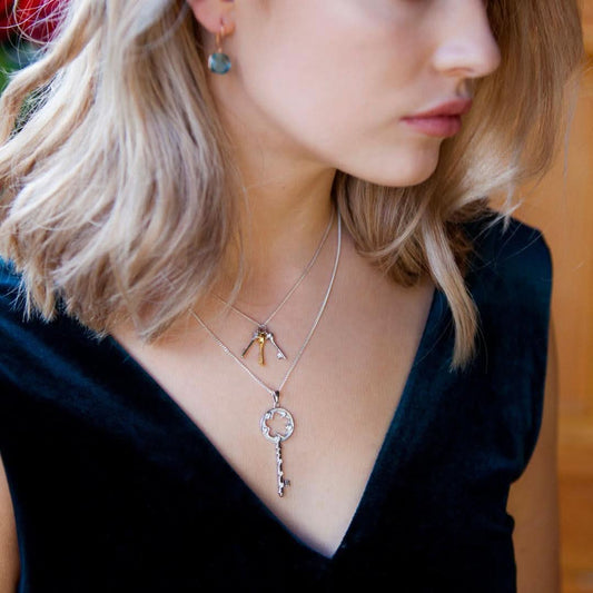 model wearing bunch of key pendants with silver necklace