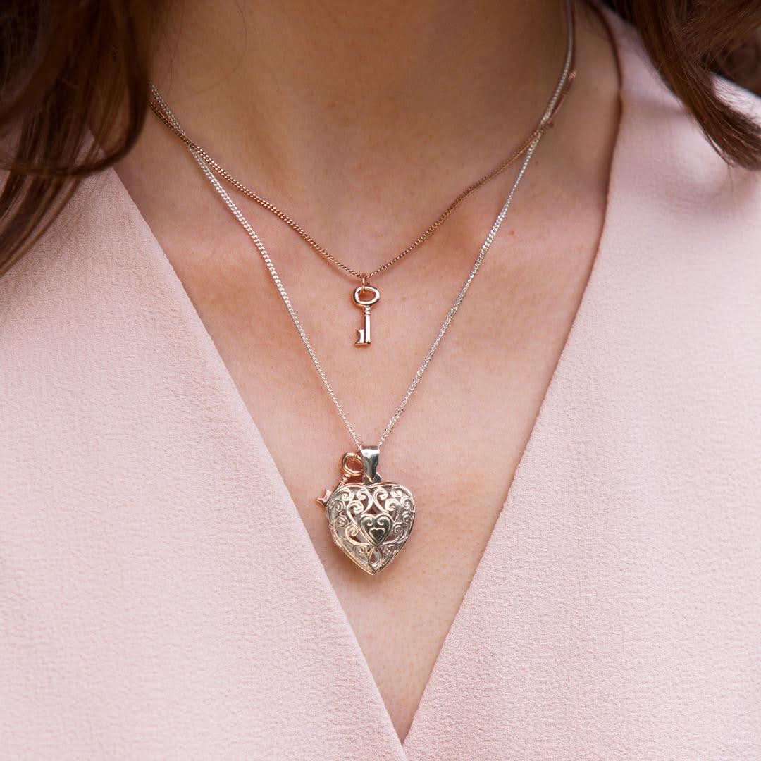 model wearing key locket in white gold with rose gold key charm on the chain
