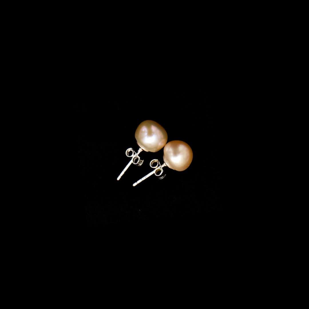 classic pearl earrings in champagne on a black background