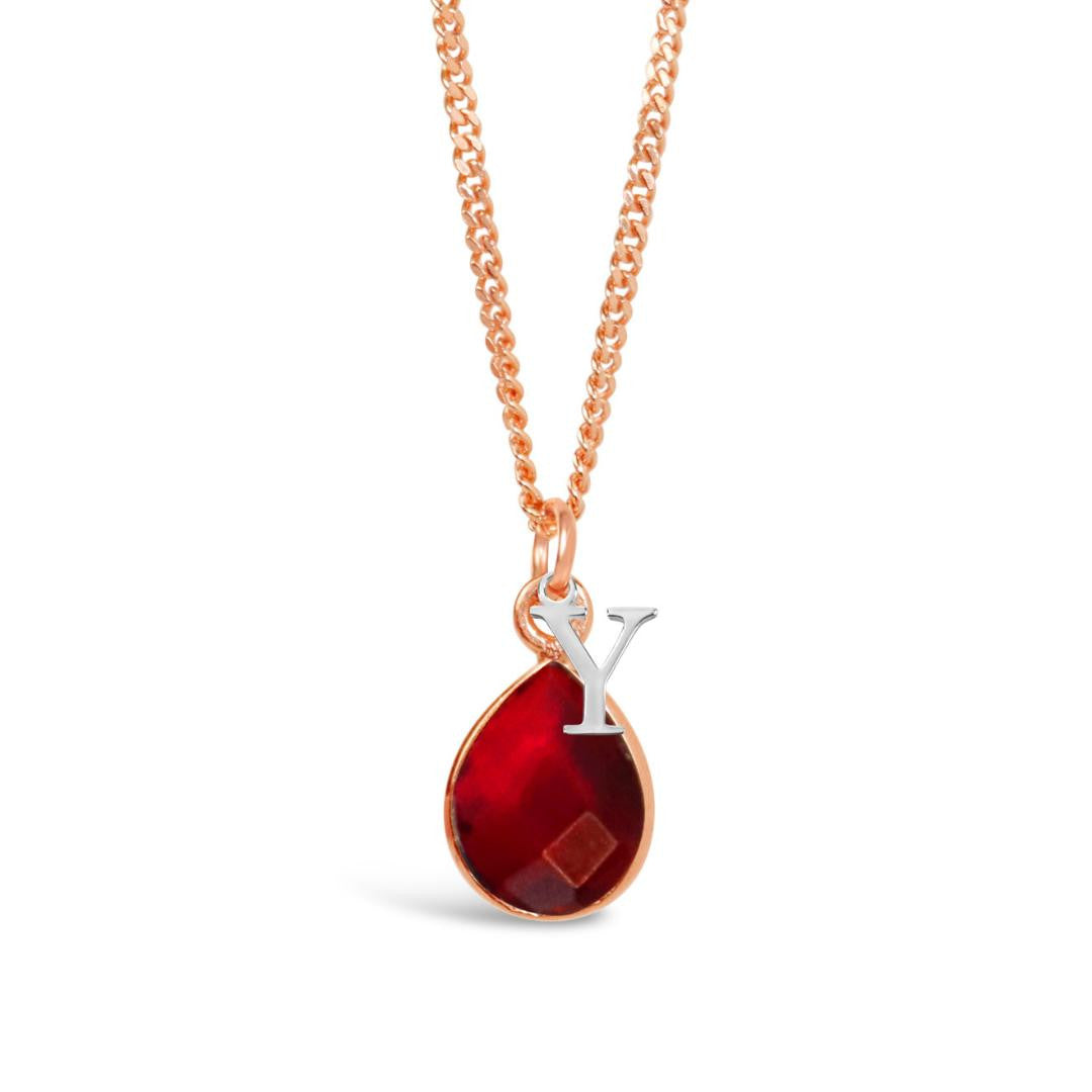 garnet charm necklace in rose gold with silver initial charm on a white background