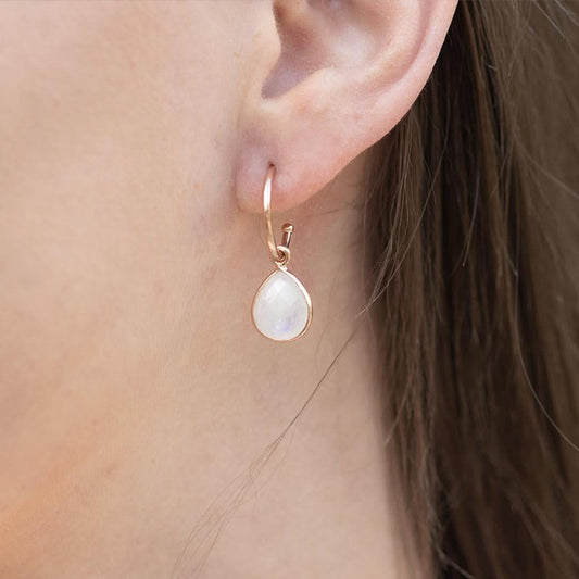 close up of model wearing moonstone drop hoop earrings