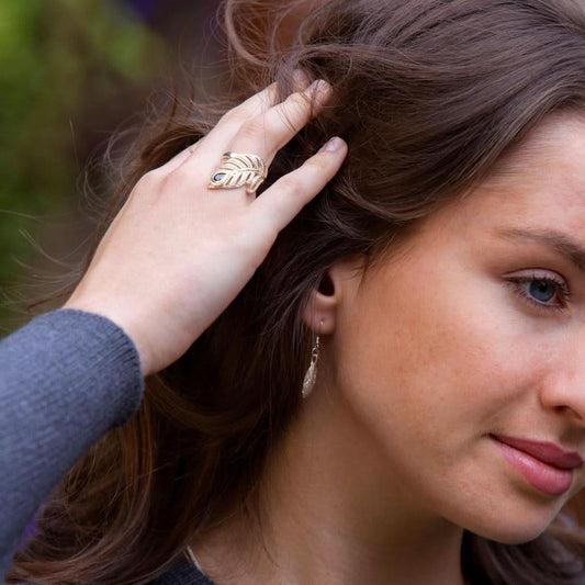 close up of model wearing silver feather earrings