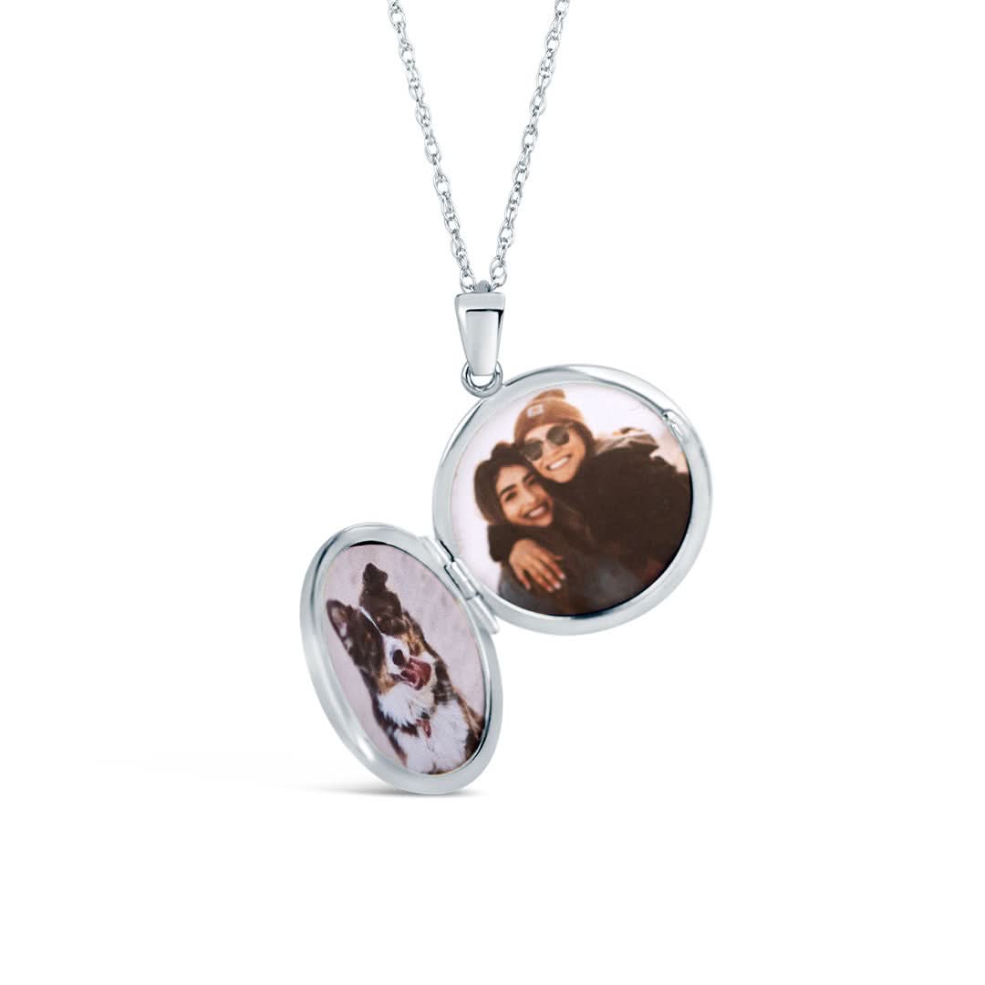 opened white gold round diamond locket with family photos inside