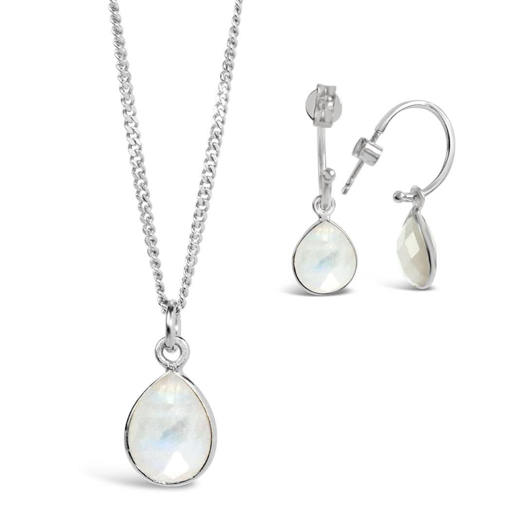 white quartz charm necklace and drop hoop earrings in silver on a white background