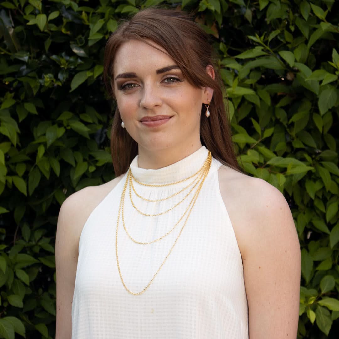 model wearing multiple sizes of gold belcher chains