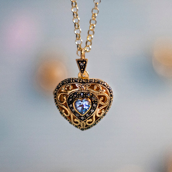 gold heart shaped locket in a vintage style hangs on a gold chain