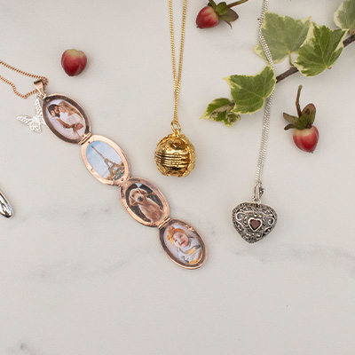 gold and silver necklaces lying on a white surface